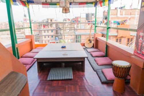 einen Balkon mit einem Tisch und einer Gitarre auf einem Gebäude in der Unterkunft Swastik Guest House in Bhaktapur