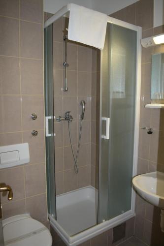 a bathroom with a shower with a toilet and a sink at Hotel Ballet School in Kaštela