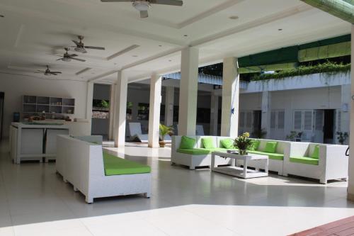 a living room with white furniture and green accents at Villa Putih Lovina in Lovina