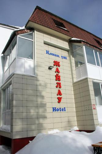 a building with a hotel sign on the side of it at Zhaylau Hotel in Shchūchīnsk