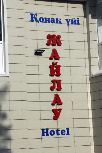 a hotel sign on the side of a building at Zhaylau Hotel in Shchūchīnsk