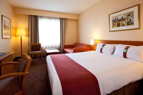 a hotel room with a large bed and a window at Holiday Inn Gent Expo, an IHG Hotel in Ghent