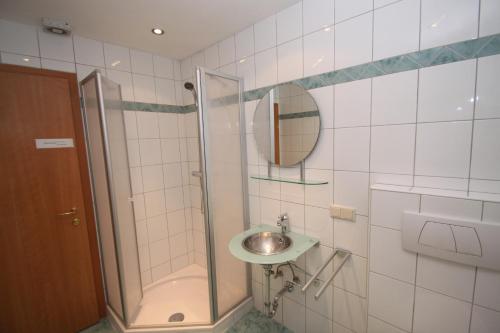 a bathroom with a sink and a shower with a mirror at Appartements Reiterhaus in Wagrain
