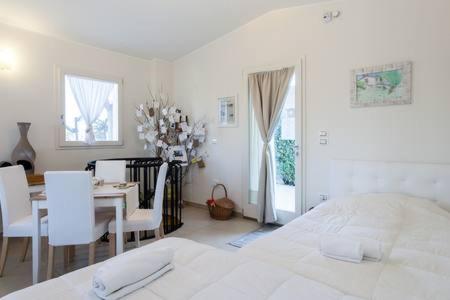 a bedroom with a white bed and a table and chairs at La Casetta in Tavullia