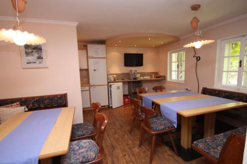 a dining room with tables and chairs and a kitchen at Appartements Reiterhaus in Wagrain