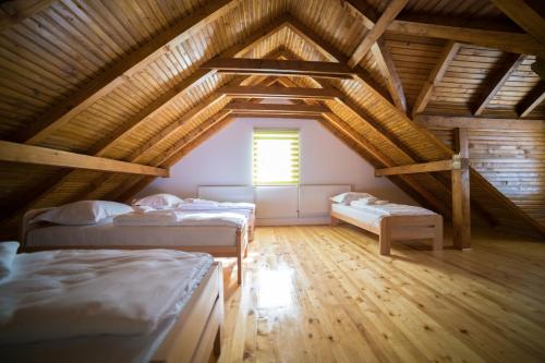 a attic room with two beds and a window at Vila "Volujak" in Tjentište