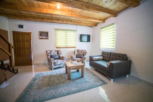 a living room with a couch and chairs and a table at Vila "Volujak" in Tjentište