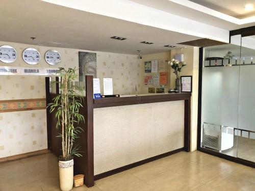 a restaurant with a counter and a plant in a room at Blue Paseo Grande Inn in Naga