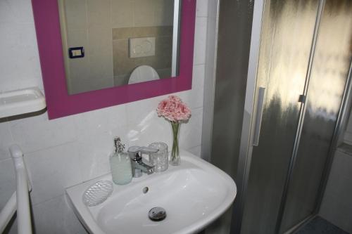 La salle de bains est pourvue d'un lavabo et d'un vase de fleurs. dans l'établissement Affittacamere La Branda, à La Spezia