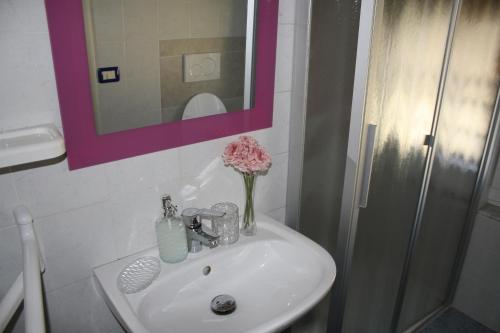 umywalkę w łazience z wazonem kwiatów w obiekcie Affittacamere La Branda w mieście La Spezia