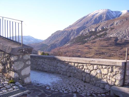 a stone retaining wall with a mountain in the background at LITTLE TOWER in Aielli