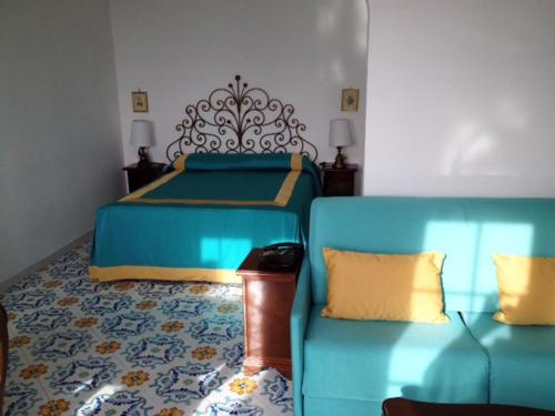 una camera con un letto, un divano e un letto di Hotel Residence Villa Igea Capri a Capri