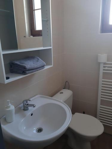 a white bathroom with a sink and a toilet at Penzion V Zatáčce in Plzeň