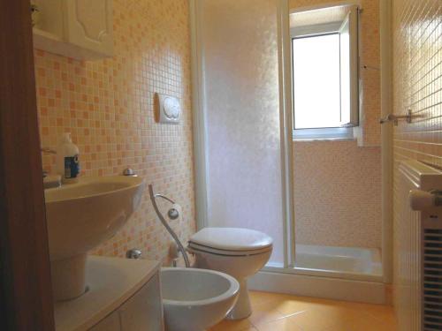 bagno con servizi igienici, lavandino e finestra di CASA MIA a Rapallo