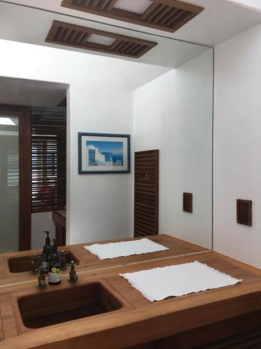 a bathroom with a wooden sink and a mirror at te Whare -Lake Tarawera tree-top nest in Lake Tarawera