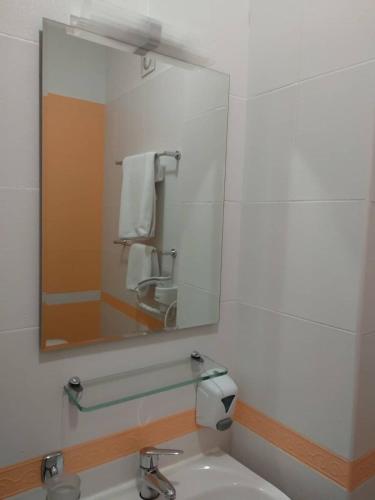 a bathroom with a mirror and a sink at Hotel Villa Natali in Chişinău
