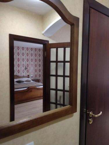 a mirror in a room with a bed and a bedroom at Hotel Villa Natali in Chişinău