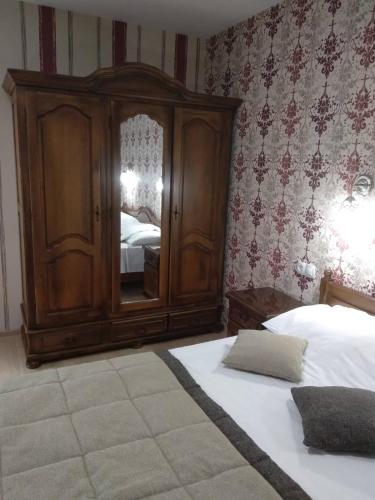 a bedroom with a large wooden cabinet and two beds at Hotel Villa Natali in Chişinău