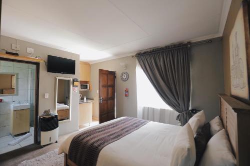 a hotel room with a bed and a television at Ledumo Guest lodge in eMalahleni