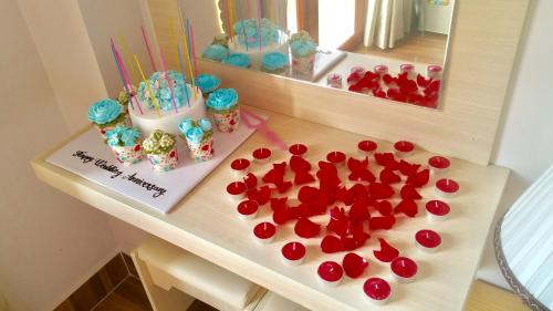 a table with a cake and some red paper hearts at Golden Bee Hotel in Da Lat