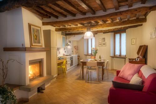 sala de estar con chimenea y sofá rojo en La casa sul ponte, en Mercatello sul Metauro