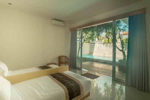 sypialnia z 2 łóżkami i widokiem na basen w obiekcie Villa Bahagia by Bukit Vista w mieście Jimbaran