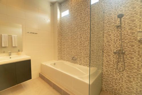 W łazience znajduje się prysznic, wanna i umywalka. w obiekcie Villa Bahagia by Bukit Vista w mieście Jimbaran