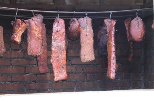a bunch of meat hanging on a brick wall at Karczma Karnasów in Cisna