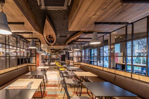 a restaurant with tables and chairs and windows at ibis Styles Warszawa Centrum in Warsaw
