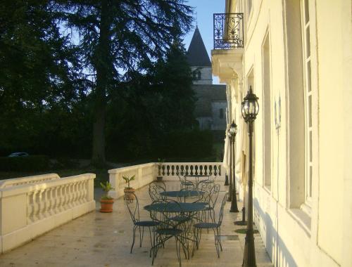 a patio with tables and chairs and a building at Le Chateau de Prauthoy in Prauthoy