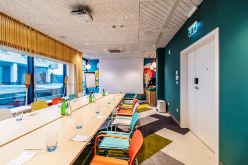 a long row of tables and chairs in a room at ibis Styles Warszawa Centrum in Warsaw