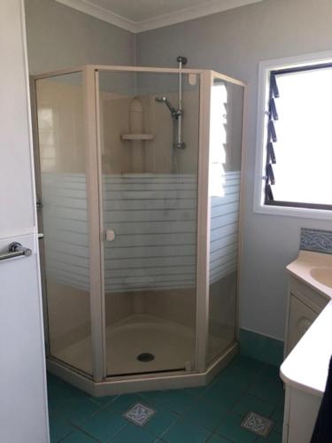 um chuveiro com uma porta de vidro na casa de banho em LOUISA em Townsville
