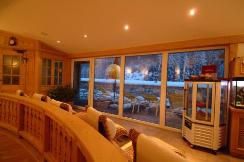 a balcony with chairs and a large glass window at Hotel Sportalm in Gerlos