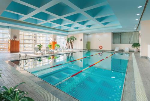 uma grande piscina com um tecto azul em Hotel Nikko Dalian em Dalian