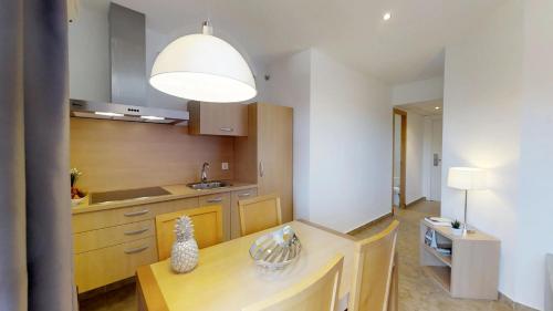 a kitchen with a table and a large light fixture at Leo Punta Umbría - Adults Only in Punta Umbría