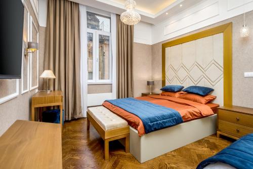 una camera da letto con un grande letto con cuscini arancioni e blu di Royal Knez a Belgrado