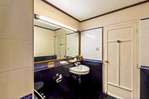 baño con lavabo y espejo grande en Grand Hotel en Kochi