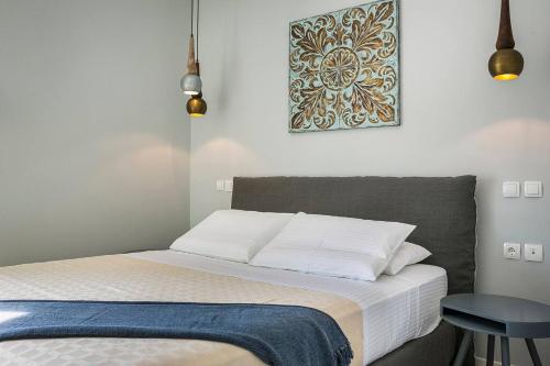 ein Bett in einem Schlafzimmer mit einem Bild an der Wand in der Unterkunft Julia's Luxury Suites, Cephallonia near Argostoli in Kástron