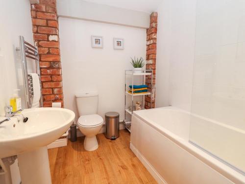 y baño con lavabo, aseo y bañera. en Commonwood Cottage, en Wrexham