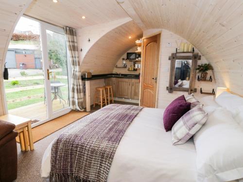 a bedroom with a large bed and a kitchen at Gelert Pod in Tremeirchion