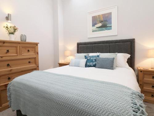 een slaapkamer met een groot bed met blauwe kussens bij Hazel Barn in Falmouth