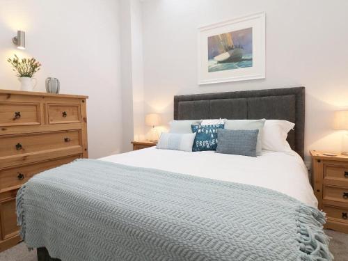 Un dormitorio con una cama grande con almohadas azules. en Hazel Barn, en Falmouth