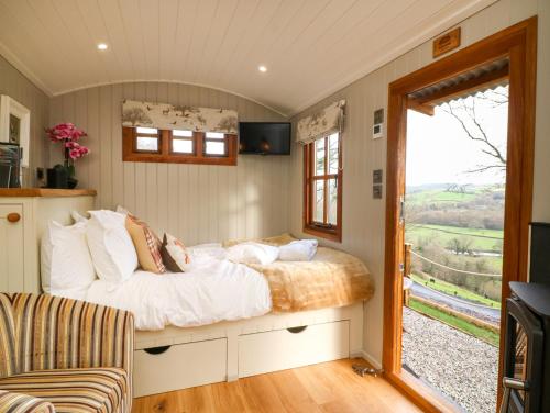 a bedroom with a bed and a sliding door at Little Silver Fox in High Bickington