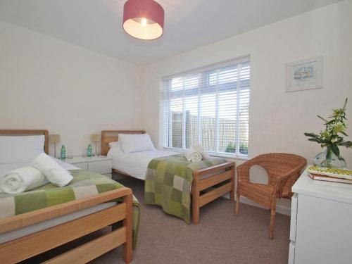 a bedroom with two beds and a window at Seagrass in Newquay