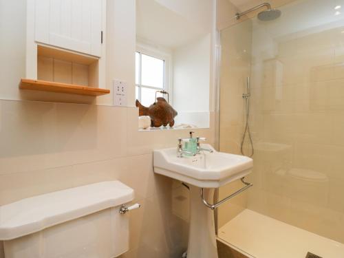 a bathroom with a sink and a toilet and a shower at Wallerthwaite Barn Cottage in Harrogate