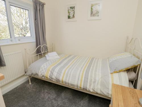 a bedroom with a bed and a window at 5 Ceirnioge Cottages in Betws-y-coed