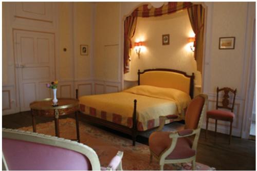 PrauthoyにあるLe Chateau de Prauthoyのベッドルーム1室(ベッド1台、テーブル、椅子付)