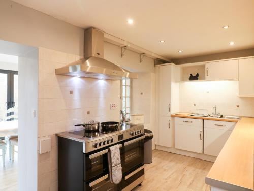 a kitchen with a stove top oven in a room at Brimpts Cottage in Postbridge