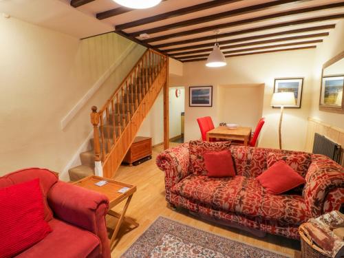 a living room with two couches and a staircase at Edrydd in Harlech
