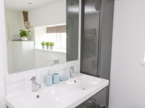 a white bathroom with a sink and a mirror at 3 Poole End in Clitheroe